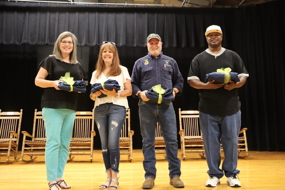 staff members standing on stage smiling